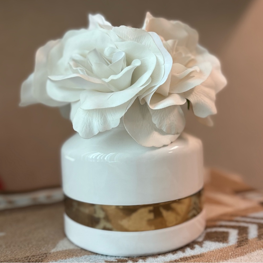Artificial white flowers in white and gold vase